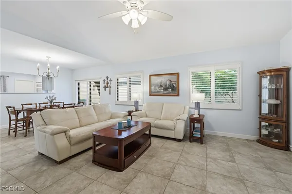a living room with furniture and a dining table with kitchen view