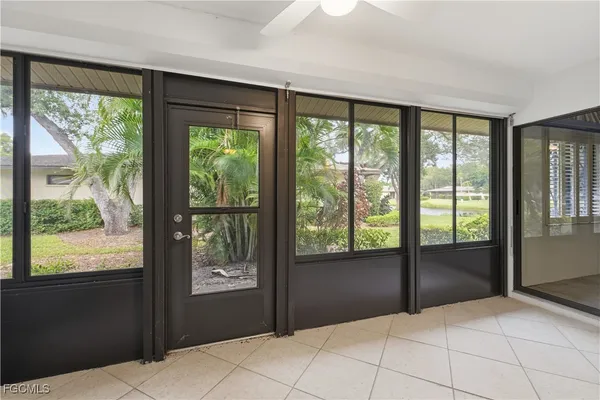 a bedroom with a large bed couch and two windows