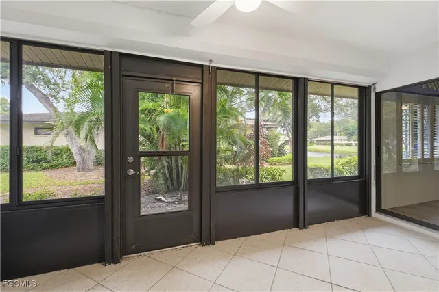 a bedroom with a large bed couch and two windows