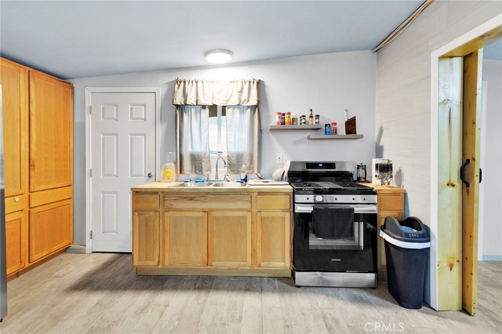25333 Valley View Road Apple Valley, CA 92308 - Photo 6 of 37 a kitchen with stainless steel appliances granite countertop a stove a sink and a refrigerator
