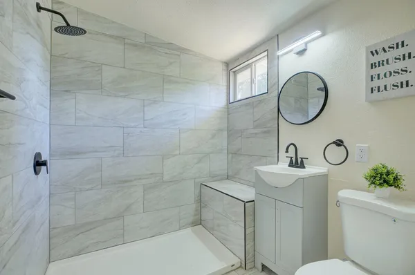 a bathroom with a toilet sink and mirror
