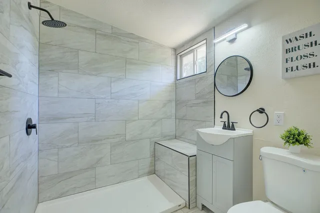a bathroom with a toilet sink and mirror