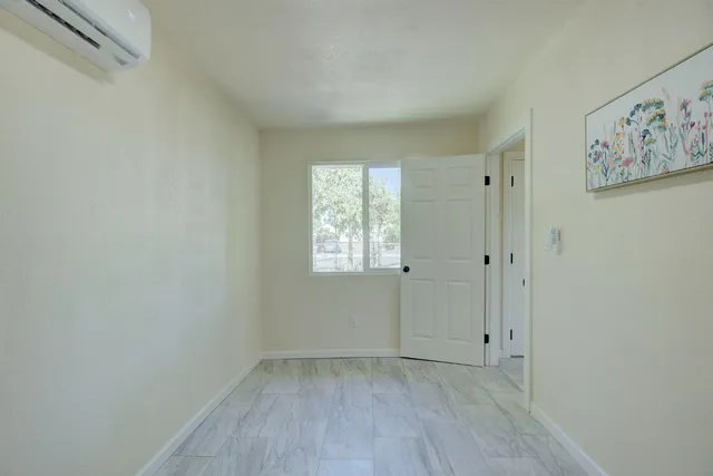 a view of empty room with window and wooden floor