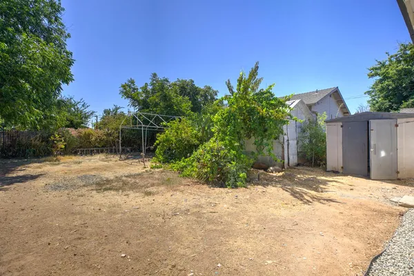 a view of a house with backyard and trees