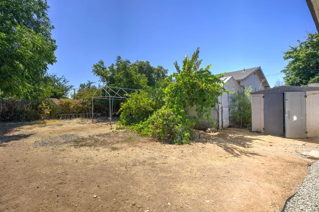 a view of a house with backyard and trees