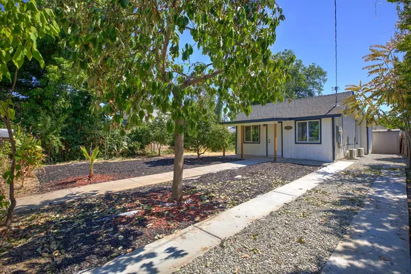 a front view of a house with a garden