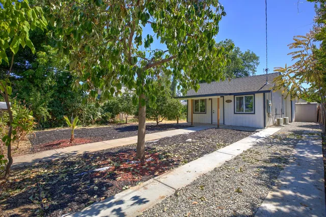 a front view of a house with a garden