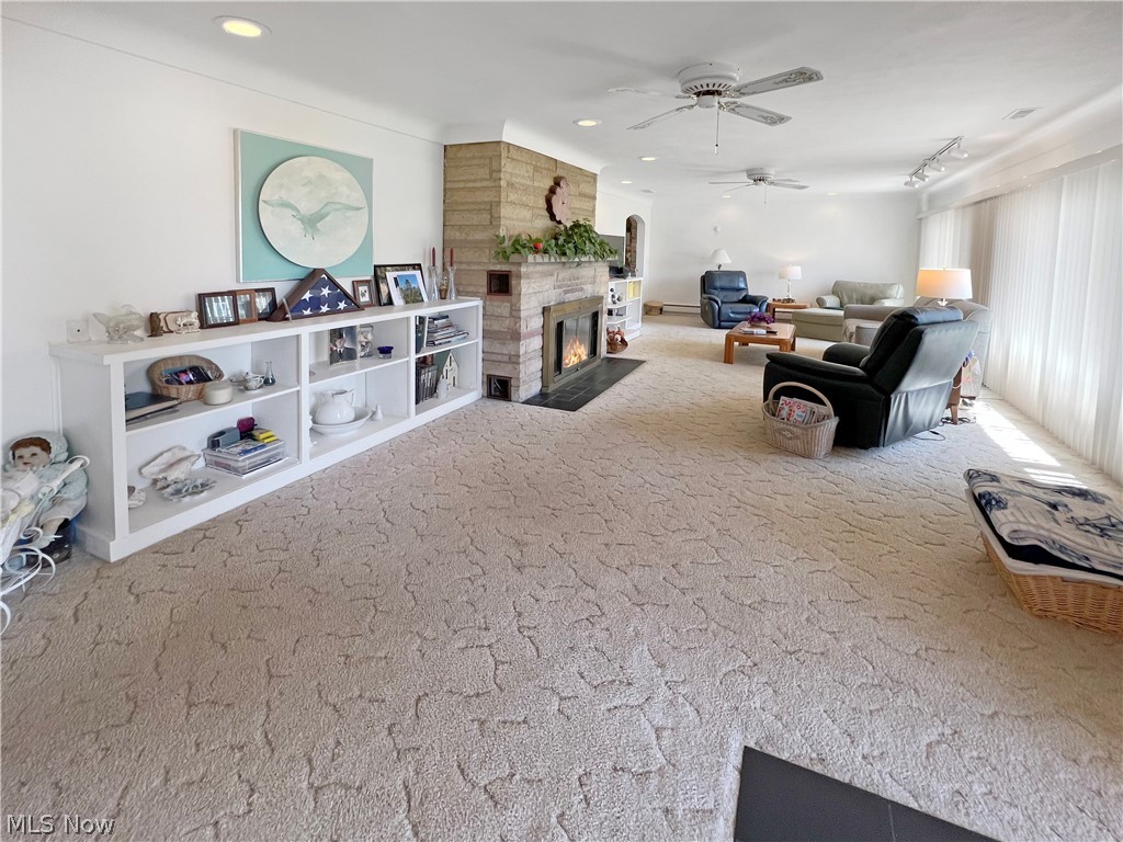 4663 East Harbor Road Port Clinton, OH 43452 - Photo 21 of 31 Game room with light colored carpet, ceiling fan, and a stone fireplace