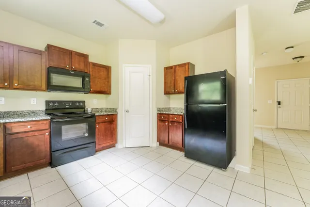 a kitchen with stainless steel appliances granite countertop a refrigerator and a stove top oven