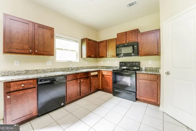 a kitchen with stainless steel appliances granite countertop a stove a sink and a microwave
