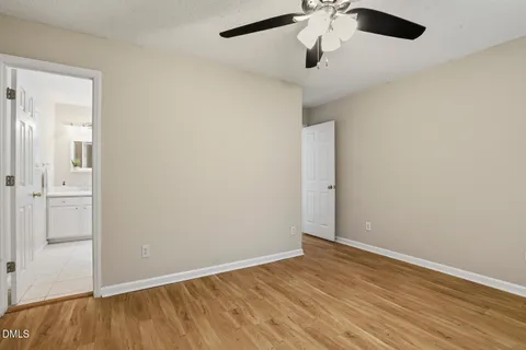 an empty room with a ceiling fan and wooden floor