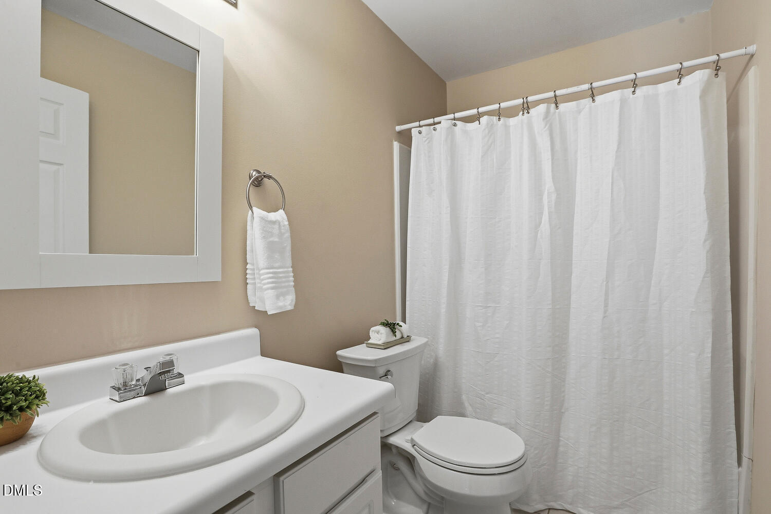 1220 Stoneferry Lane Raleigh, NC 27606 - Photo 21 of 40 a bathroom with a sink a toilet and a mirror
