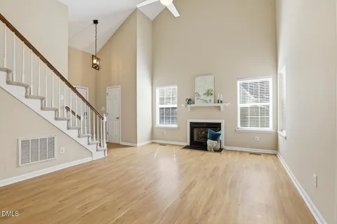 a view of a livingroom with wooden floor fireplace and windows