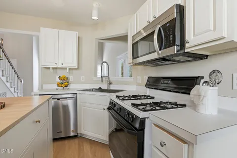 a kitchen with cabinets appliances a sink and a stove