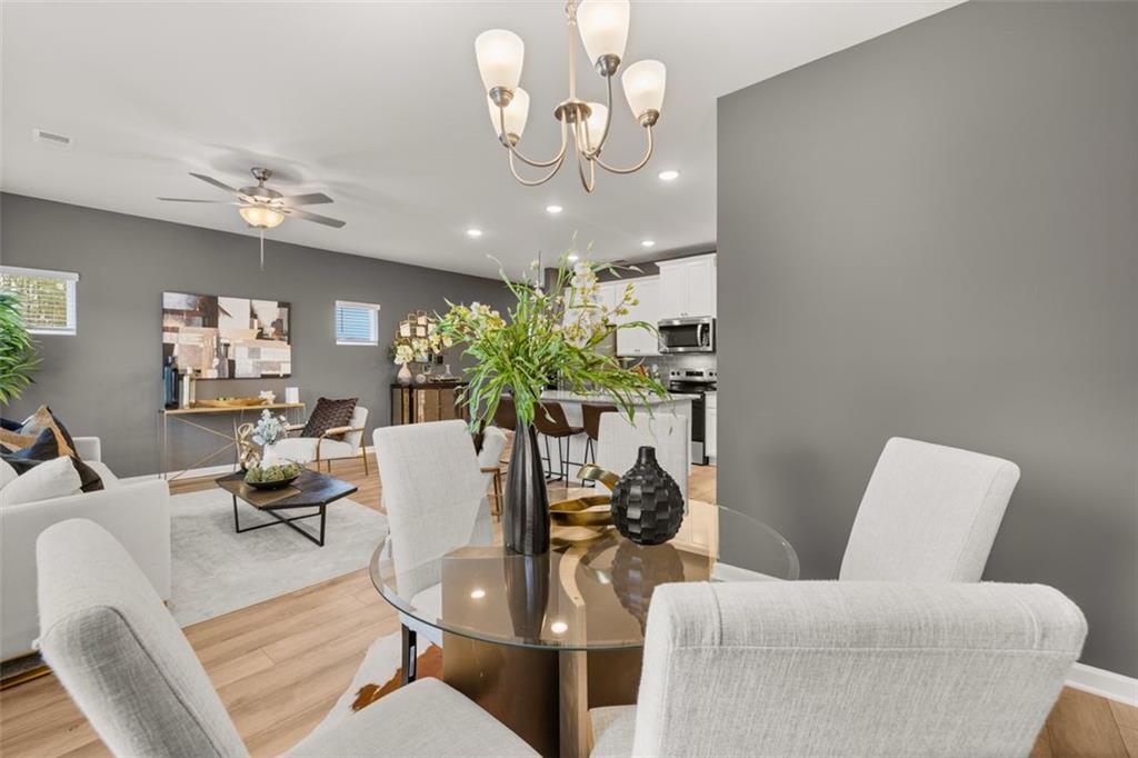 241 Epping Street, Unit 88 Stockbridge, GA 30281 - Photo 22 of 64 a living room with furniture a chandelier and a dining room
