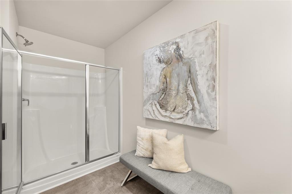 241 Epping Street, Unit 88 Stockbridge, GA 30281 - Photo 45 of 64 a white room with a white comforter and a painting on the wall