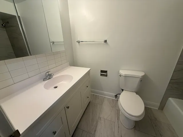 a white toilet sitting next to a bathroom sink