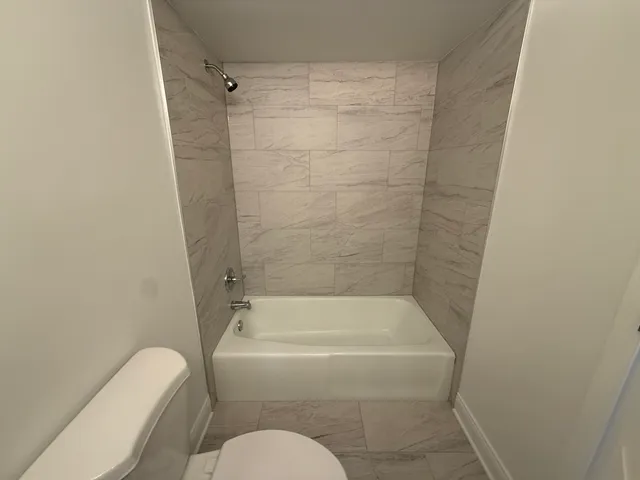 a bathroom with a toilet and a bath tub