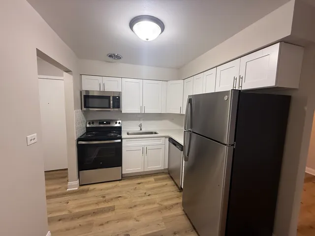 a kitchen with a refrigerator and a stove top oven