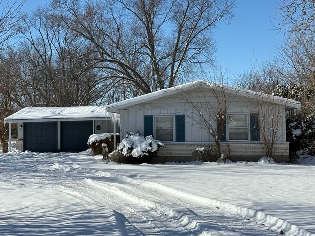 a view of a house with a yard covered in snow