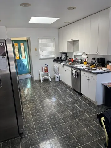 a kitchen with stainless steel appliances a sink a stove a refrigerator and cabinets