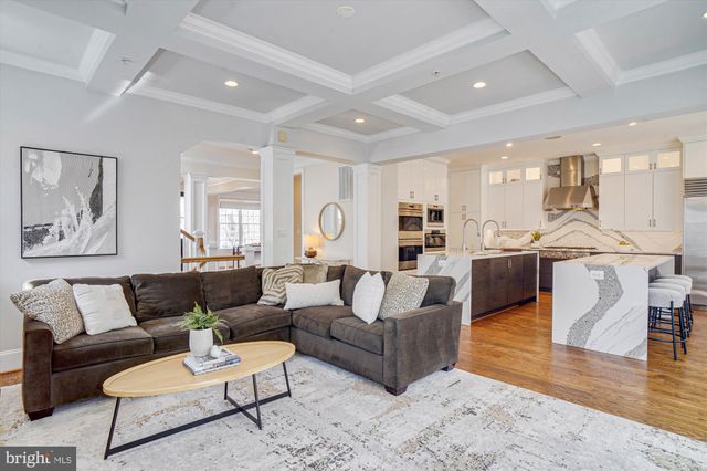 a large white kitchen with lots of counter space dining table and stainless steel appliances