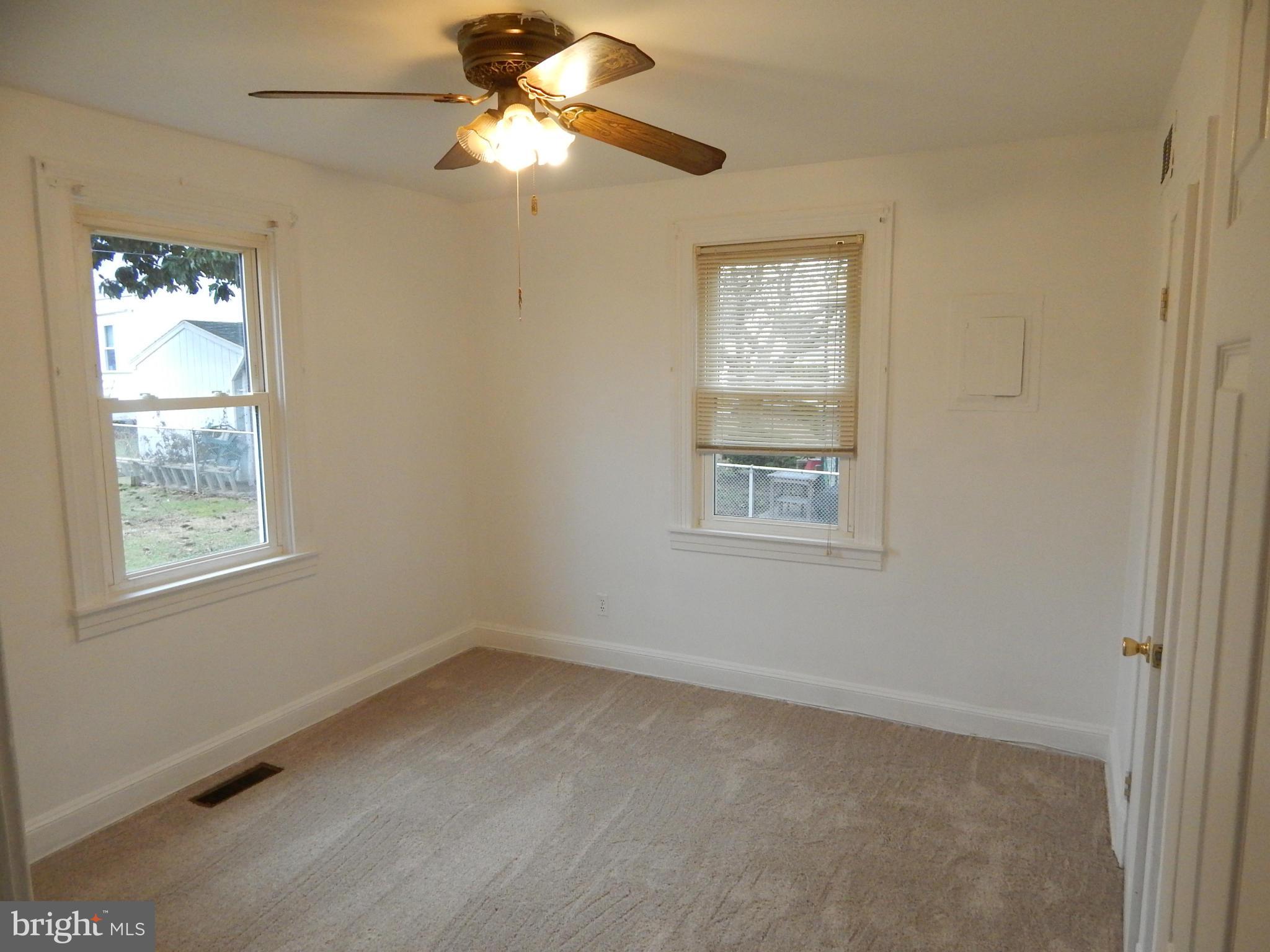 19 Riverside Road Essex, MD 21221 - Photo 5 of 16 an empty room with windows and fan