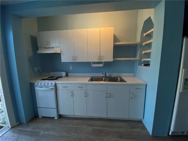 a kitchen with a sink cabinets and a window