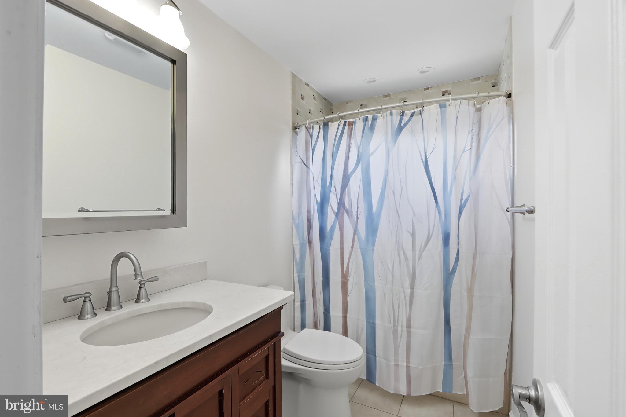 1206 Gettig Road Baltimore, MD 21237 - Photo 16 of 38 a bathroom with a granite countertop sink toilet and a mirror