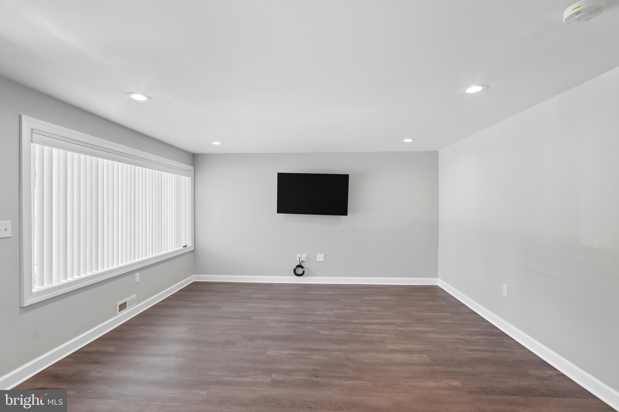 1206 Gettig Road Baltimore, MD 21237 - Photo 5 of 38 a view of an empty room with wooden floor and windows