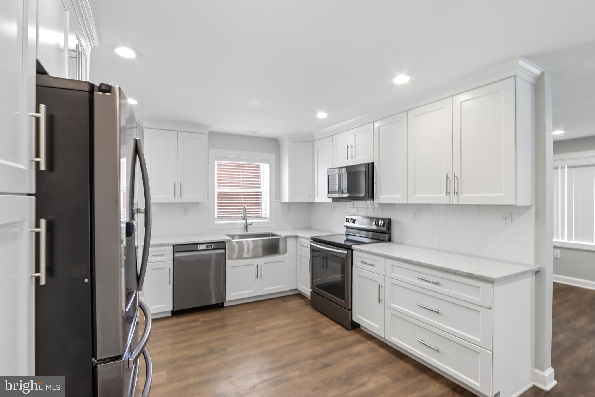 1206 Gettig Road Baltimore, MD 21237 - Photo 9 of 38 a kitchen with cabinets stainless steel appliances and window
