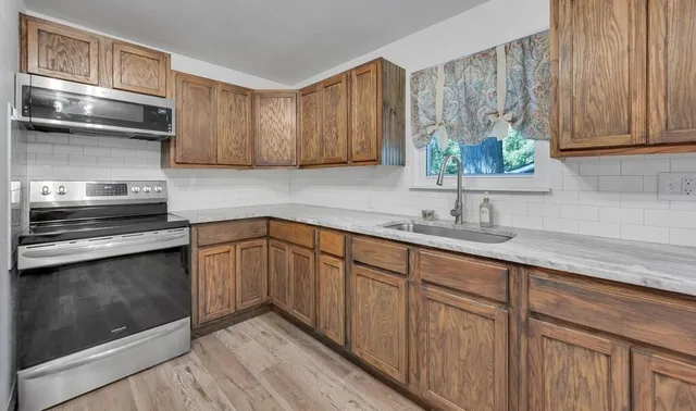 a kitchen with stainless steel appliances granite countertop a sink and a stove