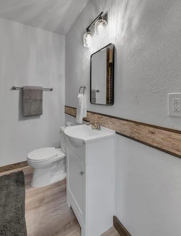 a bathroom with a sink vanity mirror and toilet