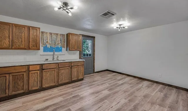 a kitchen with a sink cabinets and wooden floor