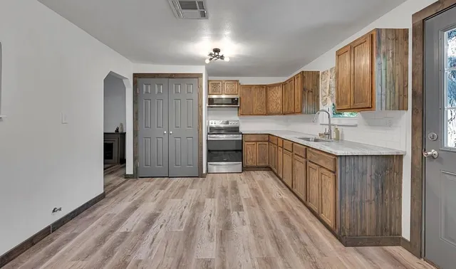 a kitchen with stainless steel appliances granite countertop a refrigerator and a sink