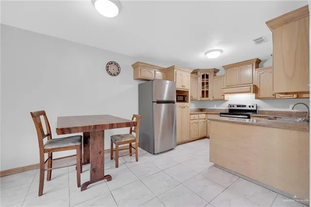 a kitchen with refrigerator and chairs
