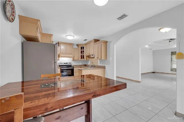 a kitchen with stainless steel appliances granite countertop a sink refrigerator and cabinets