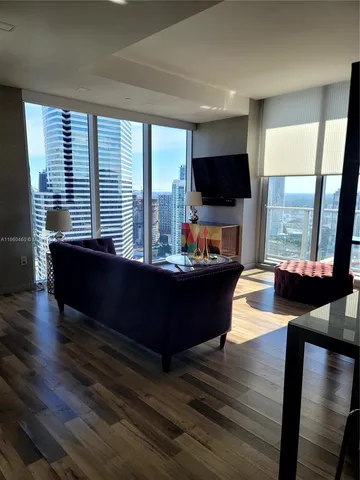a living room with furniture flat screen tv and a large window