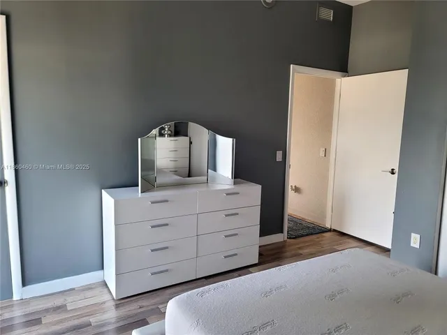 a room with a dresser and wooden floor