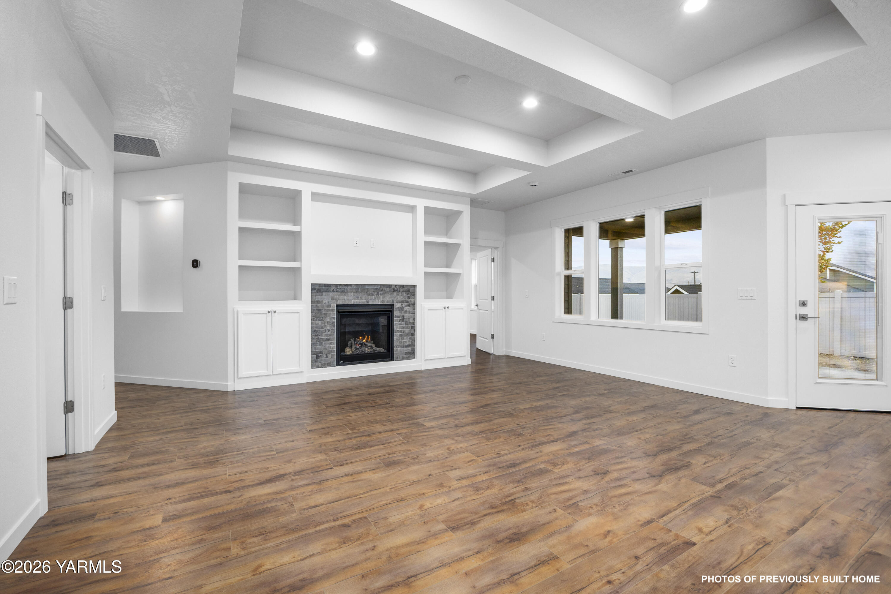 211 Packer Street Prosser, WA 99350 - Photo 19 of 31 an empty room with wooden floor fireplace and windows