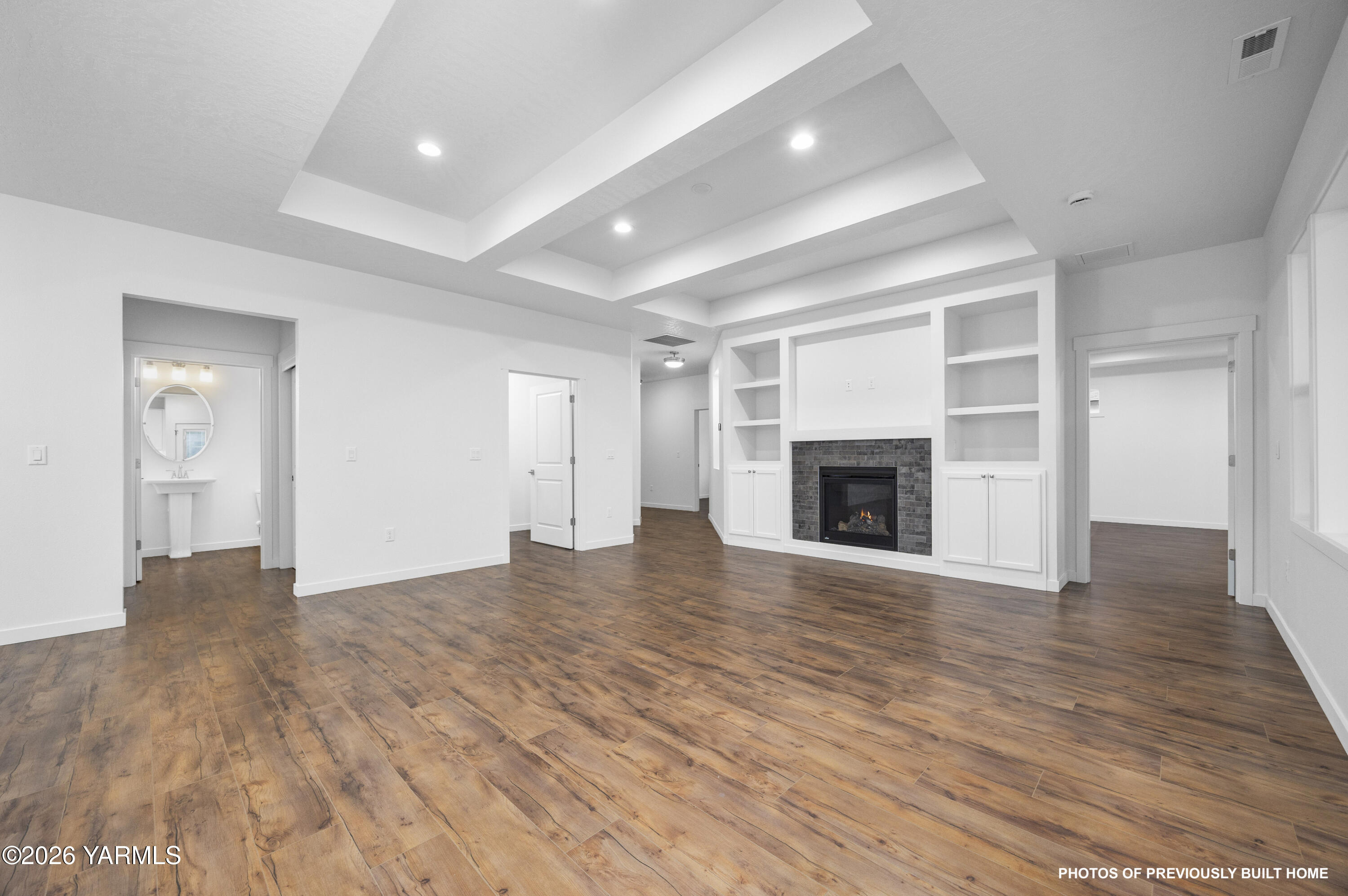 211 Packer Street Prosser, WA 99350 - Photo 20 of 31 a view of an empty room with wooden floor and a fireplace