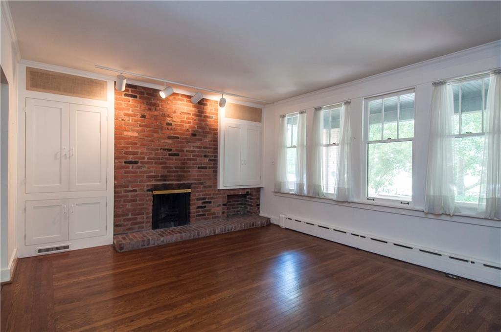 5640 Marlborough Road Pittsburgh, PA 15217 - Photo 3 of 16 Living room has oak flooring and a wood-burning fireplace, flanked by built-in cabinets.