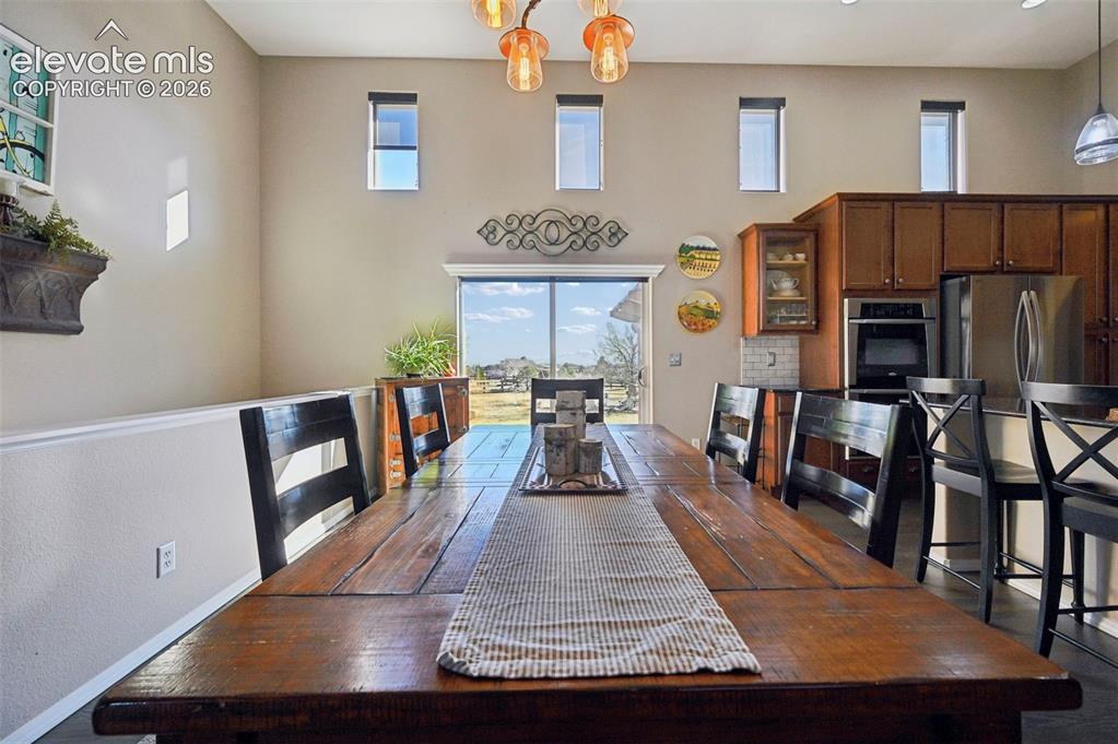 7216 Sylamore Way Peyton, CO 80831 - Photo 7 of 30 Open-concept interior featuring a substantial wood-finish dining table and coordinated seating