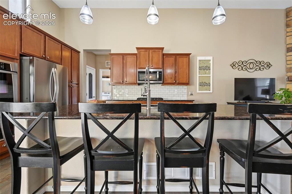 7216 Sylamore Way Peyton, CO 80831 - Photo 8 of 30 Kitchen island featuring a dark speckled countertop
