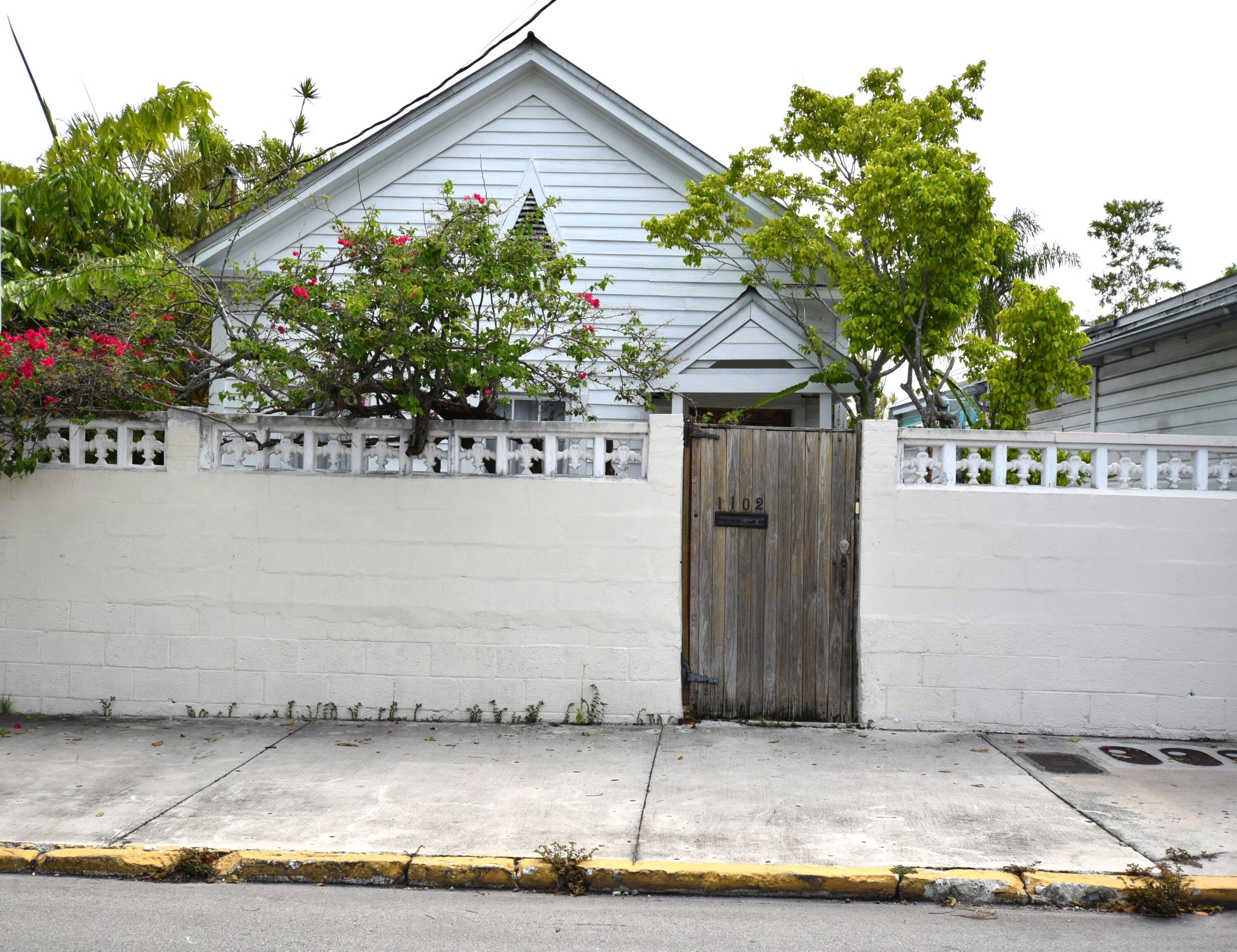 1102 Whitehead Street Key West, FL 33040 - Photo 1 of 22 a front view of a house with a garden