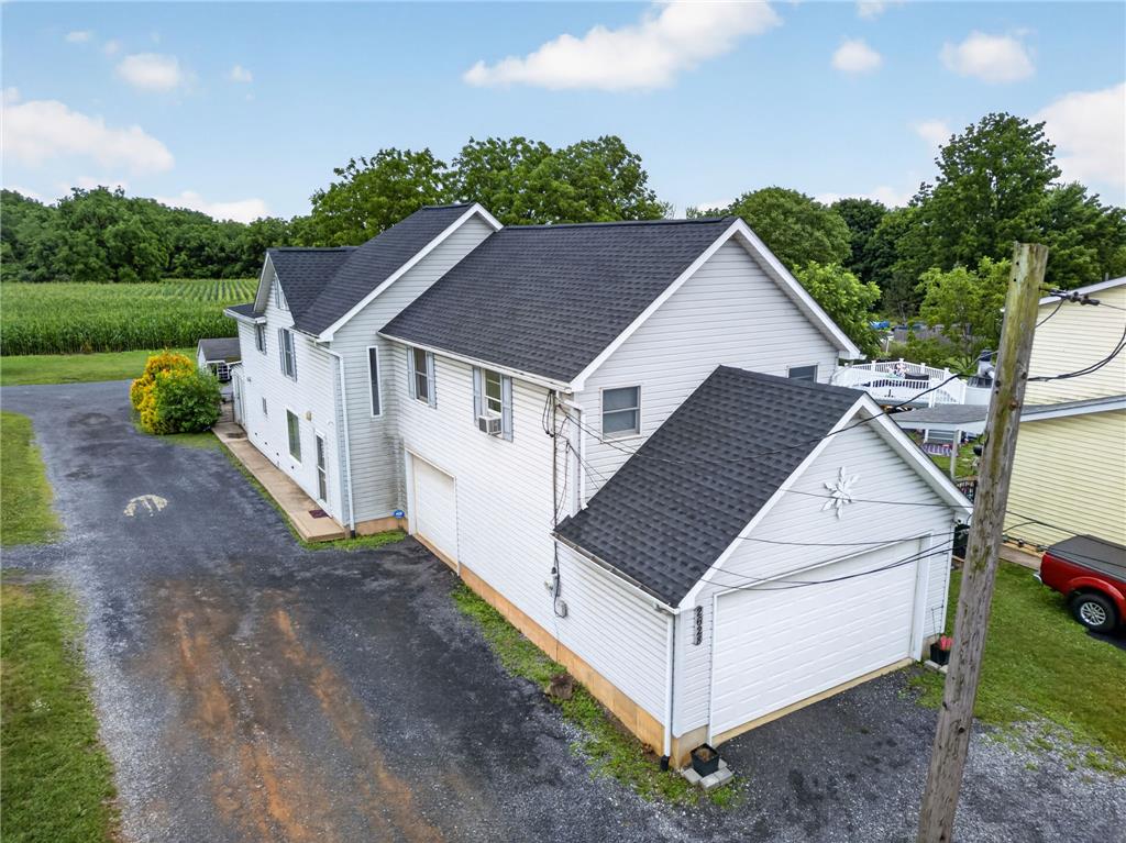 2628 Levans Road Coplay, PA 18037 - Photo 3 of 54 A side aerial view showcases the property's multiple garages and extensive driveway, framed by a rural landscape.