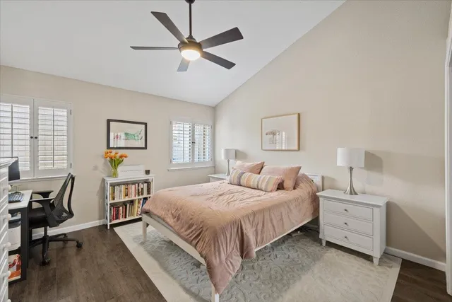 a bedroom with a bed a computer on the desk and chair