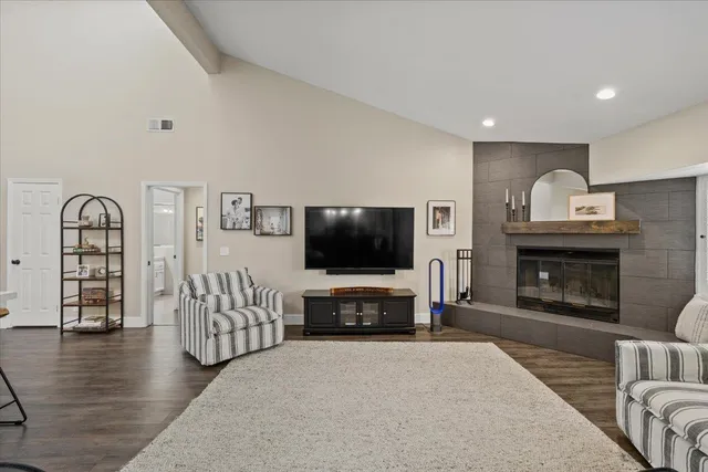 a living room with furniture a flat screen tv and a fireplace