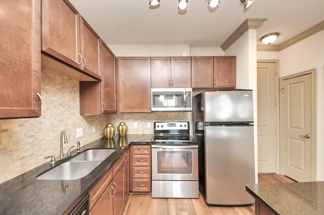 a kitchen with kitchen island a stove a chandelier and a refrigerator