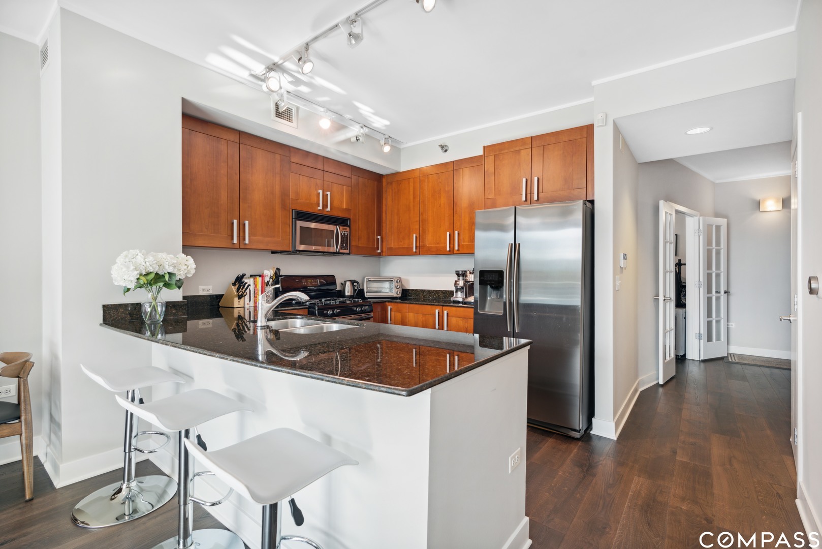 744 North Clark Street, Unit 704 Chicago, IL 60654 - Photo 5 of 12 a kitchen with stainless steel appliances granite countertop a refrigerator a sink a stove a dining table and chairs